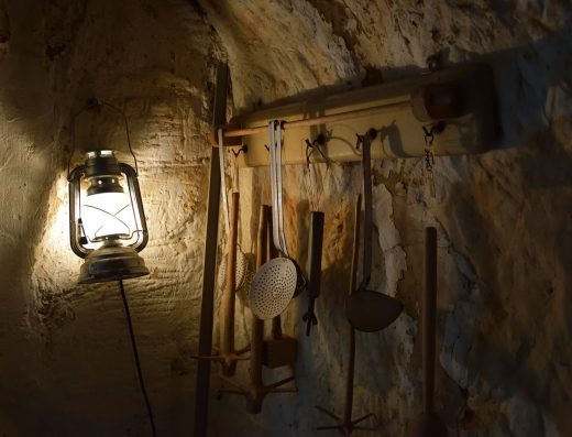Lanterne allumée accrochée à un mur de pierre dans une cave, photo de démonstration