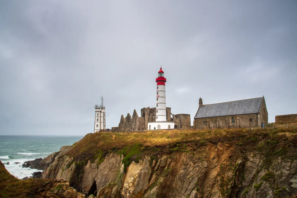 Ruines d’abbaye et phare de la pointe Saint-Mathieu sous un ciel d’orage, Bretagne