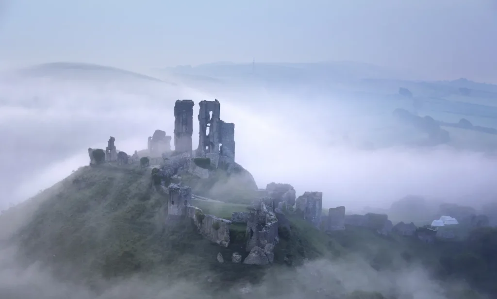 Ruines de château sur une butte au-dessus de la brume, Auvergne-Rhône-Alpes